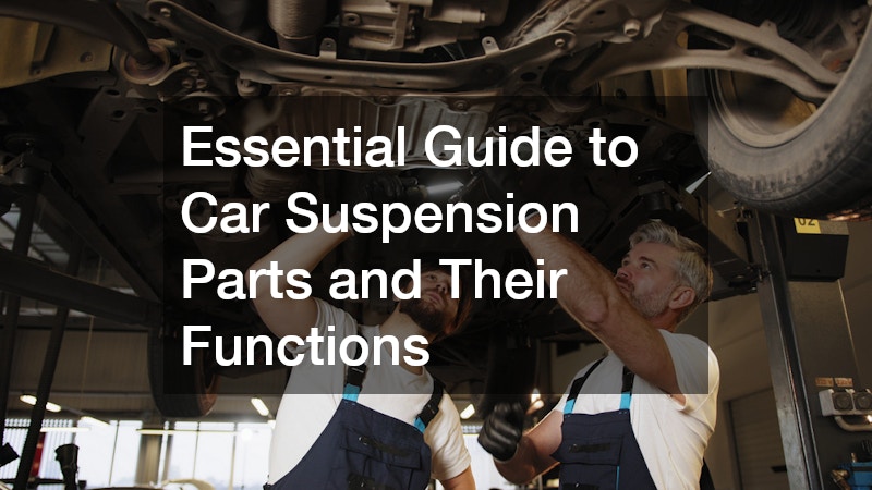 two mechanics inspecting a car's suspension system